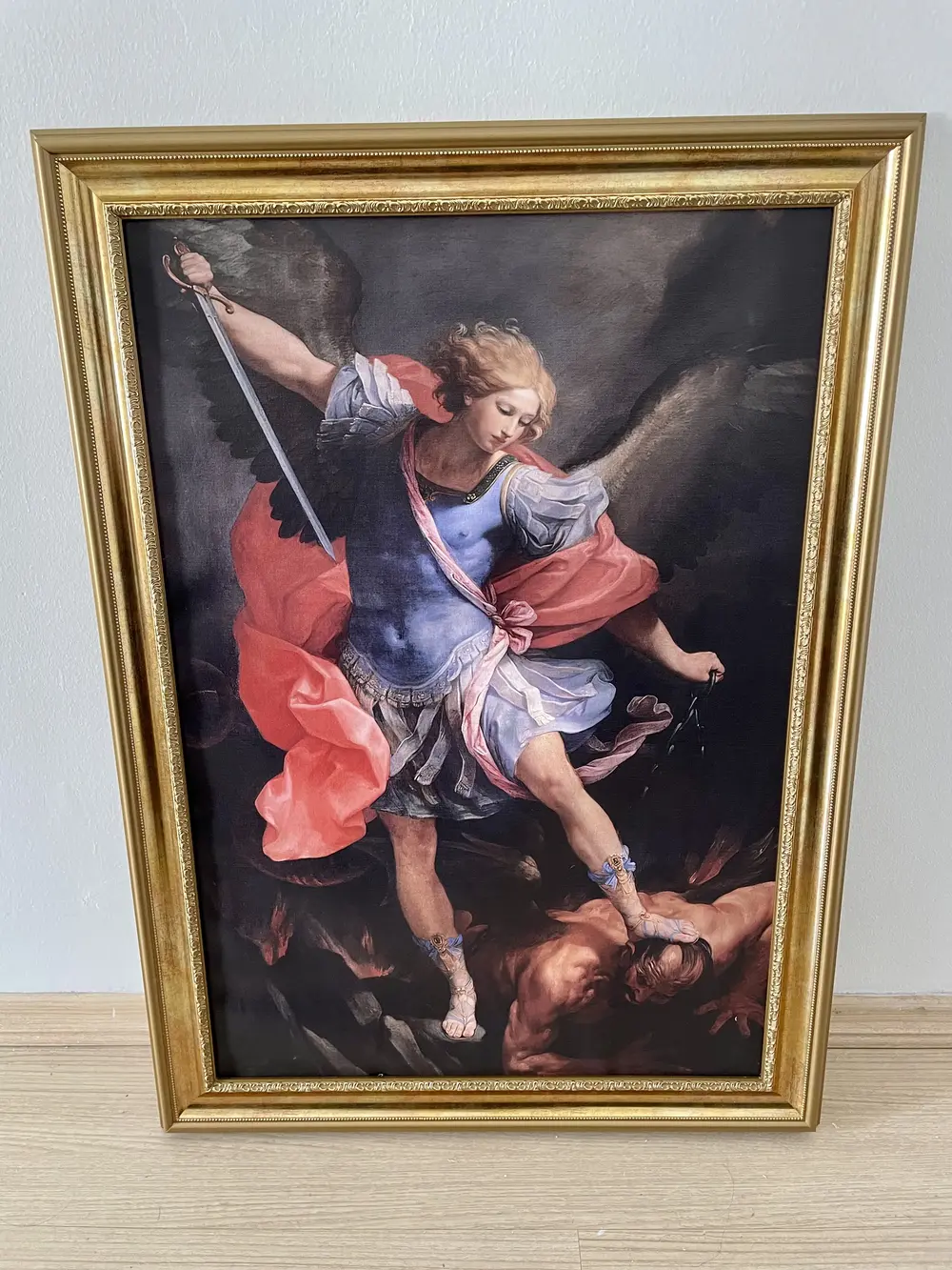 A framed 'The Archangel Michael Defeating Satan' painting.